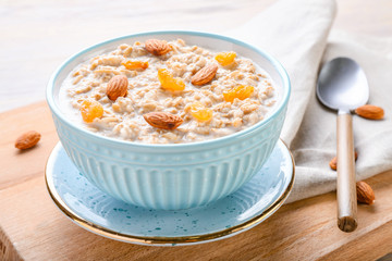 Bowl with tasty sweet oatmeal on table