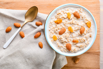 Bowl with tasty sweet oatmeal on table