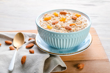 Bowl with tasty sweet oatmeal on table