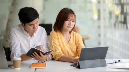 Obraz premium Cropped shot of two businesspeople sitting in glass glass wall office room