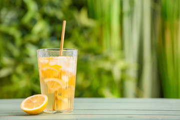 Glass with cold tea on table outdoors