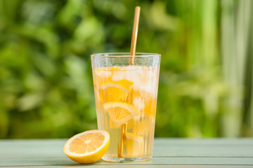 Glass with cold tea on table outdoors