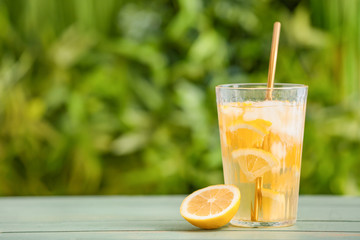 Glass with cold tea on table outdoors