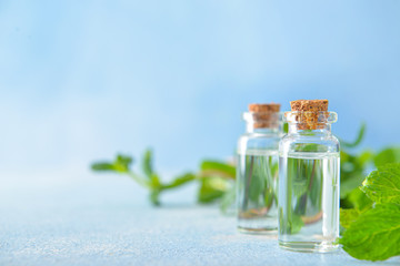 Bottles of mint essential oil on table