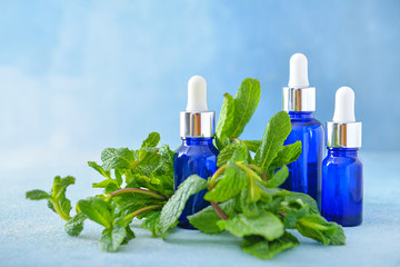 Bottles of mint essential oil on table