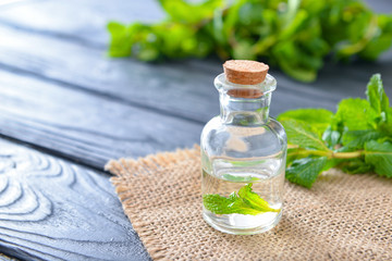 Bottle of mint essential oil on table