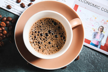 Cup of hot coffee and newspaper on table