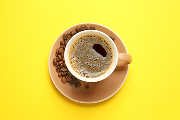 Cup of hot coffee on color background