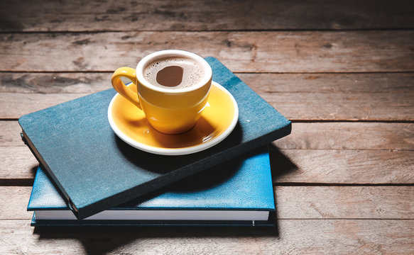 Cup Of Hot Coffee And Books On Wooden Table