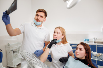 The dentist makes the examination. the Intern observes