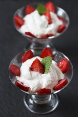 cheese cream. whipped curd cream with strawberries. Homemade cottage cheese is whipped with cream.  A useful dessert. On a dark background.