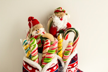 Classic striped christmas candy canes with tiny handmade christmas toys,in christmas-patterned home slippers