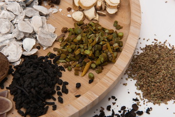 A group of herbs on a white background, large Chinese herbs in a wooden bowl, close-up of medicinal plants and aromatic plants