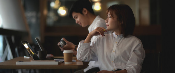 Obraz premium Cropped shot of young businesswoman thinking about her project while sitting next to her colleague