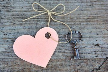 Heart and antique key on the background of old natural wood. Blank for a postcard with your text. The view from the top