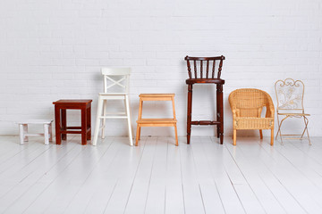 There are many different chairs in the white room. The concept of unity of different