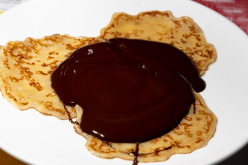 Pancakes with chocolate on a white background.