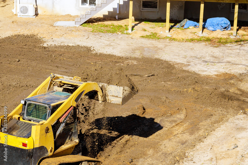 Wall mural mini bulldozer with earth doing landscaping works