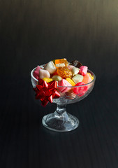 Traditional Colorful Turkish Candies,Akide in glass candy bowl on black surface.The Sugar Feast.