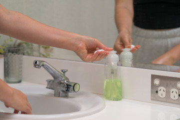 woman washing hands in basin