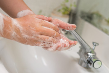 woman washing hands in basin