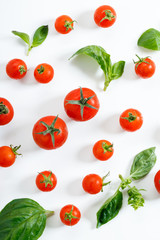 red cherry tomato and basil leaf on white background