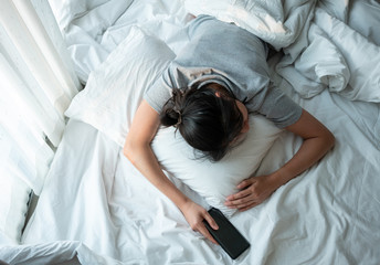 Woman sleeping with smartphone.