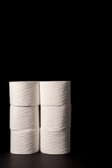 Stack of toilet paper on black background with space for text ideal for tissue paper shortage signs