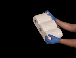 Issues related to COVID-19 Hands with surgical gloves holding toilet paper. Black background and space for text