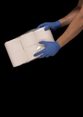 Issues related to COVID-19 Hands with surgical gloves holding toilet paper. Black background and space for text © Marco