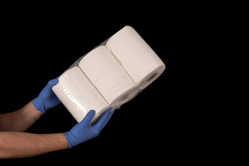 Issues related to COVID-19 Hands with surgical gloves holding toilet paper. Black background and space for text