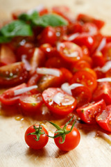 red cherry tomato and basil leaf on wooden background