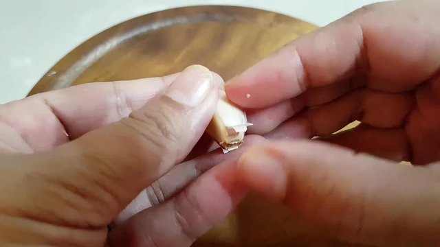 hands peeing fresh garlic