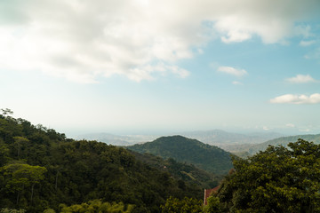 paisaje de bosques de montañas y un cielo azul y el mar al fondo