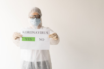 A woman in a mask and glasses holds a sheet with the inscription Coronavirus. wearing a protective...
