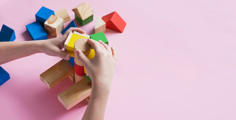 A child plays assemble with wooden cubes constructor. Education concept for children learning....