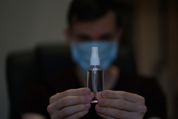 Man in protective mask and with antibacterial antiseptic gel for hands disinfection and health protection prevention during flu virus outbreak, epidemic and infectious diseases