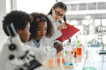 Group of teenage cute little students child learning research and doing a chemical experiment while...