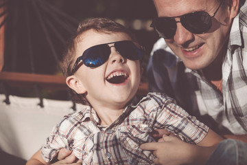 Father and son playing in the park at the day time.