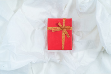 Red cardboard box for gifts, isolated, white fabric texture background