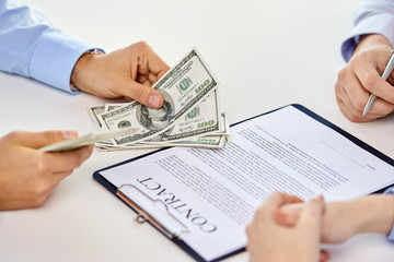 business, finance deal and people concept - close up of hands with us dollar money and contract