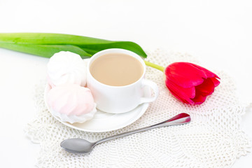 marshmallows, tea or coffee with milk and a tulip flower. on a light background. delicate breakfast, breakfast in bed. for the beloved. Surprise.