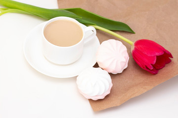 Fototapeta na wymiar marshmallows, tea or coffee with milk and a tulip flower. on a light background. delicate breakfast, breakfast in bed. for the beloved. Surprise.