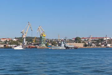 Fototapeta premium R-239 missile boat on the background of tower cranes of the Sevastopol Sea Port, Crimea