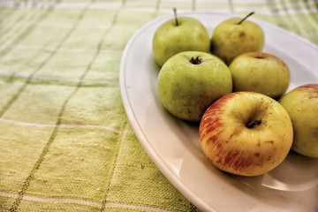 apples in a bowl on wooden table
