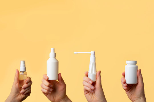 Viral disease prevention concept. Woman hands holding antiseptic spray, jar of vitamins, throat spray, chlorhexidine to protect against virus and bacteria. Coronavirus prevention. Copy space for text