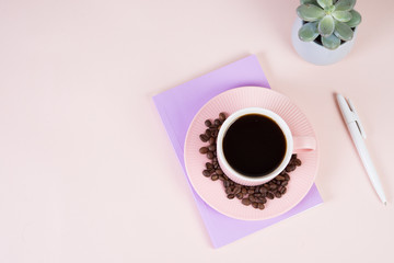 Flatlay with a Cup of black coffee on the table, a Notepad and a succulent in a ceramic pot. Desktop, business, pastel colors