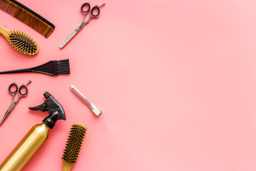Professional hairdressing set with combs, spray and sciccors on pink background top-down frame copy space