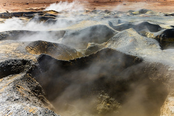 Boiling red mud pools in the geothermal area Sol de Manana in western Bolivia near Uyuni at an elevation of 15,900 feet resembling a landscape on planet mars.