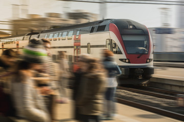 Fast commuter train rushing through the busy city station in the Lausanne city in switzerland on a...